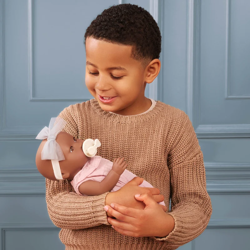 Babypuppe mit Schnuller im rosa Musselinoutfit mit Stirnband
